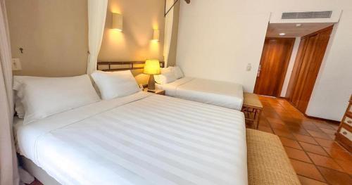 a hotel room with two beds and a lamp at Transamerica Comandatuba - All Inclusive Resort in Ilha de Comandatuba
