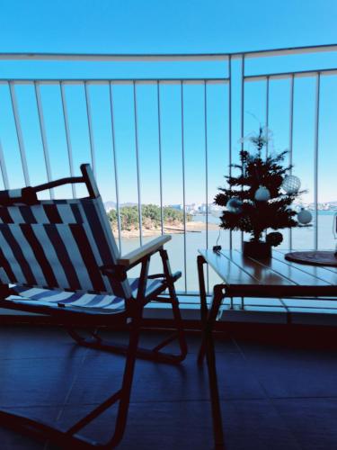 a rocking chair and a table with a christmas tree on a balcony at Cozy room Oceanview Memory Yeongjong in Incheon