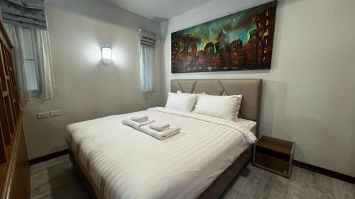 a bedroom with a bed with two towels on it at บ้านกันเอง Baan Kun Aeng Homestay in Ban Kat Nua