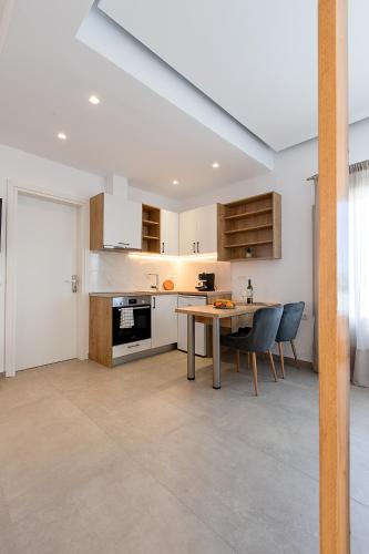 a kitchen with a table and chairs in a room at Santorini Villatzio Suites in Mesaria