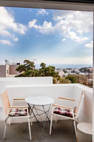 a balcony with a table and chairs and a view at Santorini Villatzio Suites in Mesaria