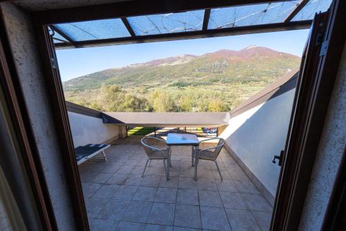 a balcony with a table and chairs and a mountain at River Hotel in Castel di Sangro