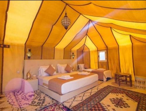 a bedroom with a bed in a tent at Sunshine luxury tent in Merzouga