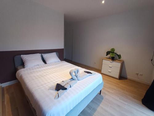 une chambre avec un grand lit et une commode dans l'établissement Hello Sunshine - Studio avec terrasse Malo Plage, à Dunkerque