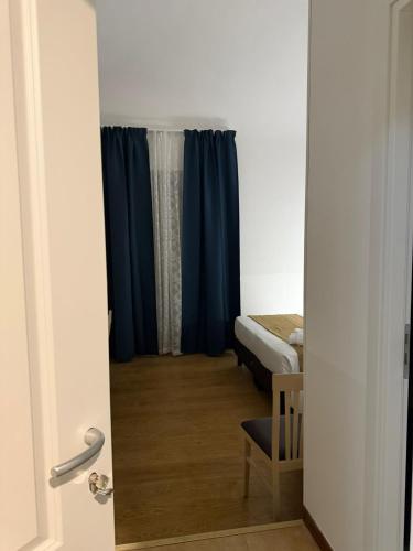 a door to a room with a bed and blue curtains at Conte GuestHouse in Rome