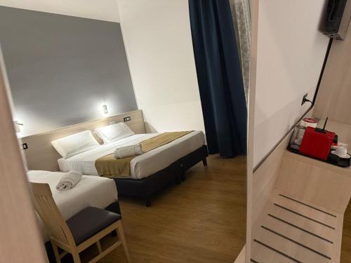 a hotel room with two beds and a chair at Conte GuestHouse in Rome