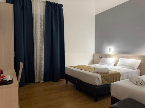 a bedroom with two beds and blue curtains at Conte GuestHouse in Rome