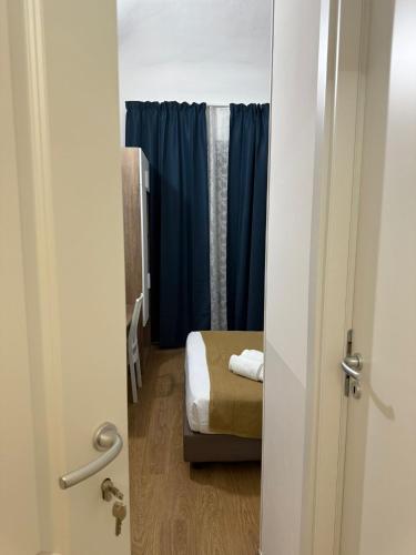 a door to a room with a bed and blue curtains at Conte GuestHouse in Rome