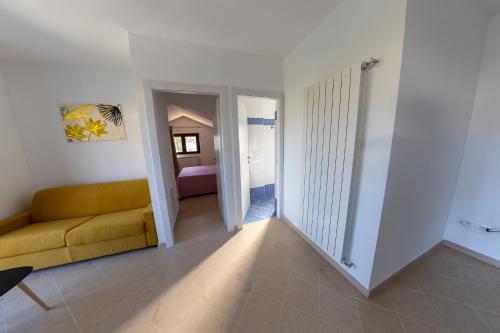 a living room with a yellow couch and a bedroom at River Hotel in Castel di Sangro