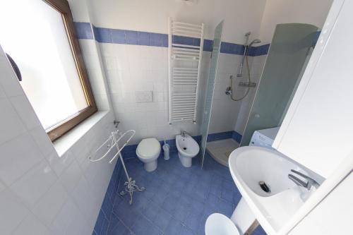 a blue and white bathroom with a toilet and a sink at River Hotel in Castel di Sangro