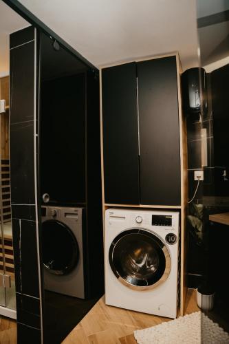 a laundry room with a washing machine and a washer at Zapato Apartment Tuzla in Tuzla