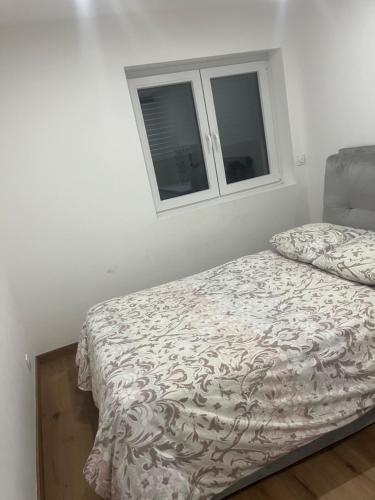 Ce lit se trouve dans un dortoir blanc doté de 2 fenêtres. dans l'établissement Appartement à Fillinges, à Fillinges