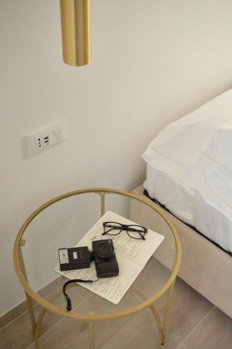 a glass table with a camera and glasses on a bed at Classic Venice House 2 in Venice