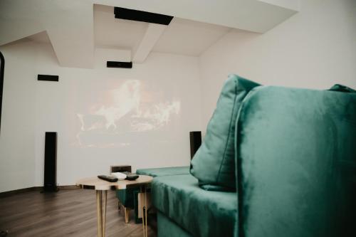 a living room with a green couch and a table at Zapato Apartment Tuzla in Tuzla