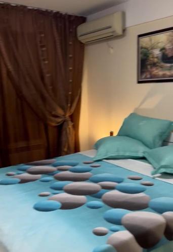 a bedroom with a bed with a blue blanket at Sunshine villa Dzhigurovo in Sandanski