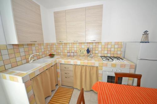 a kitchen with a sink and a white refrigerator at Casa Dei Marini in Lido Marini
