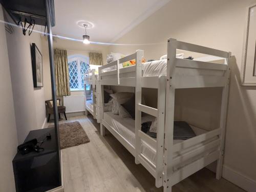 a room with two bunk beds in a room at The Stables Apartment at Cefn Tilla Court, Usk in Usk