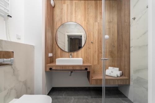 ein Badezimmer mit Waschbecken und Spiegel in der Unterkunft Jantaris - City Apartments in Mielno