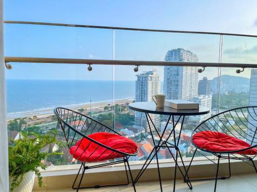 two chairs and a table in front of a window at The Song Luxury Vung Tau - Khang Apartment 1 in Vung Tau