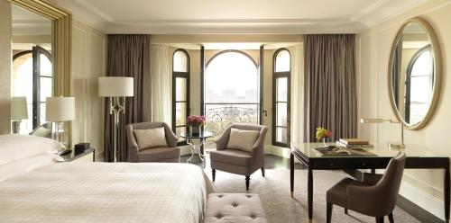 a hotel room with a bed and a desk and chairs at Four Seasons Hotel Baku in Baku