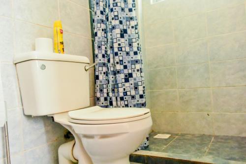 Un baño con inodoro y cortina de ducha en Mi Casa Su Casa, en Mtwapa