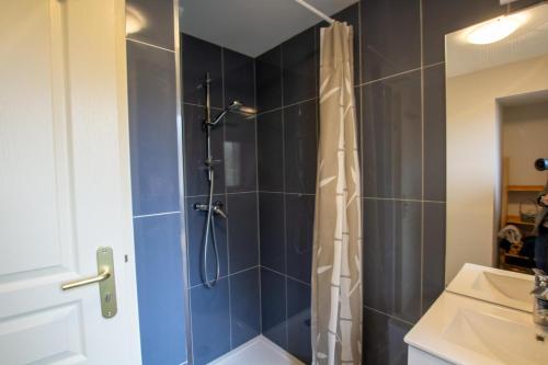 un bagno con doccia con piastrelle blu di Le moulin a vent a Nailhac