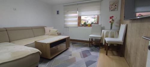 a living room with a couch and a table and chairs at Sunset Apartment in Visoko