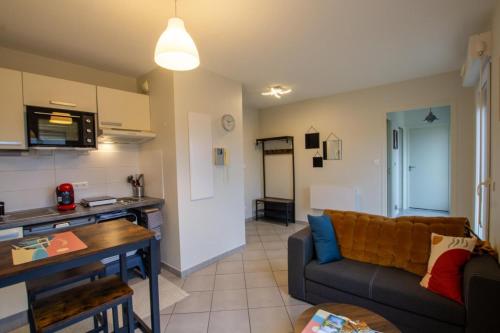 un salon avec un canapé et une cuisine dans l'établissement Gite la terrasse, à Périgueux