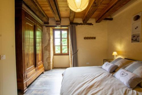 ein Schlafzimmer mit einem Bett und einem großen Fenster in der Unterkunft La bichonelle - marronnier pour 2 in Saint-Crépin-et-Carlucet