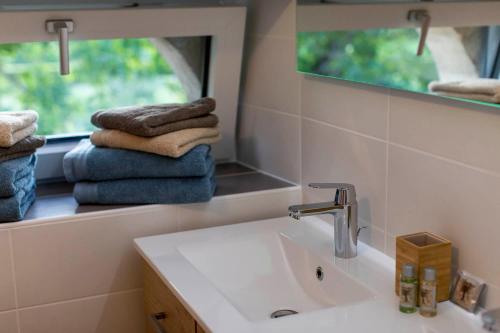 a bathroom with a sink and a mirror and towels at Le petit fort in La Roque-Gageac