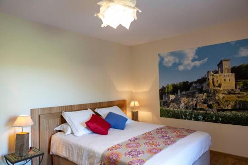 a bedroom with a bed with a painting on the wall at Le fort in La Roque-Gageac