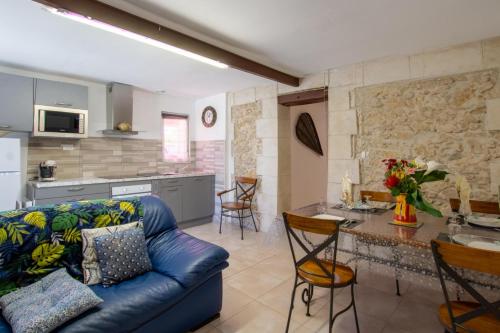 un salon avec un canapé bleu et une cuisine dans l'établissement La pergola, à Bergerac