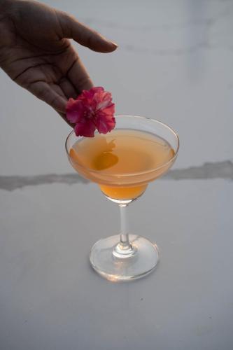a person holding a flower in a drink at Vesta Grand Central Udaipur in Udaipur
