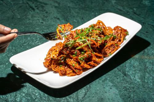 a plate of food on a plate with a fork at Vesta Grand Central Udaipur in Udaipur