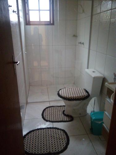 ein Badezimmer mit Dusche und Toilette und Matten in der Unterkunft Casa da Betania em Ibitipoca in Conceição da Ibitipoca