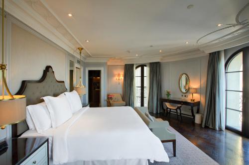 a bedroom with a large white bed and a desk at Four Seasons Hotel Baku in Baku