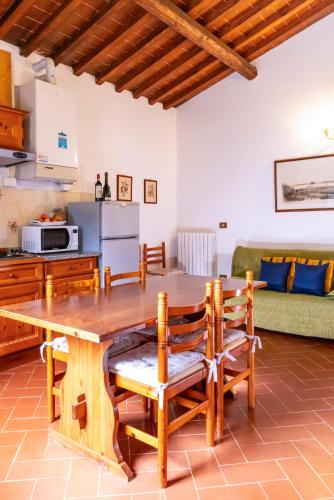 a kitchen and living room with a wooden table and chairs at Borgo Il Poggio Agriturismo in Montaione