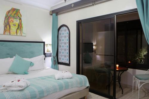 a bedroom with a bed with towels on it at Weedan Hôtel&Spa Marrakech in Oulad Snaguia