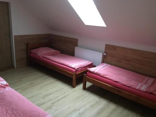 a small room with two beds and a skylight at Hrusická restaurace a penzion in Hrusice