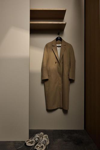 a coat and shoes are hanging on a wall at The Cloud One Düsseldorf-KöBogen in Düsseldorf