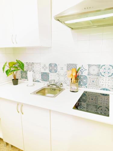 una cucina con mobili bianchi e un lavandino di APARTAMENTO COMPLETO con PATIO y TERRAZA - EL CARPIO CENTRO - CORDOBA - WiFi a El Carpio