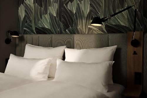 a bedroom with a bed with white pillows and a wallpaper at The Cloud One Düsseldorf-KöBogen in Düsseldorf