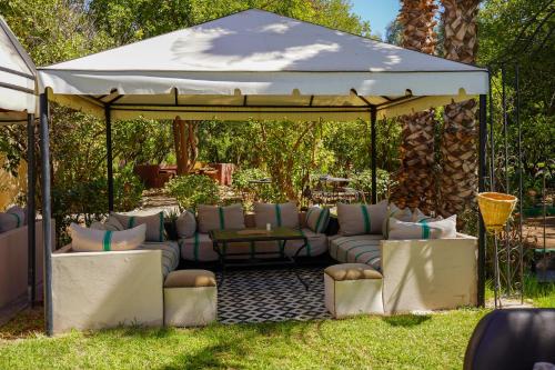 a gazebo with couches and chairs in a yard at Weedan Hôtel&Spa Marrakech in Oulad Snaguia