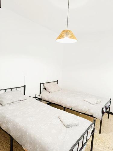due letti uno accanto all'altro in una stanza di APARTAMENTO COMPLETO con PATIO y TERRAZA - EL CARPIO CENTRO - CORDOBA - WiFi a El Carpio
