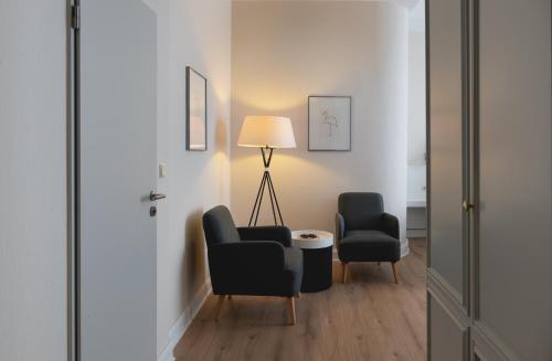 a living room with two chairs and a lamp at Rheinhotel Dreesen in Bonn