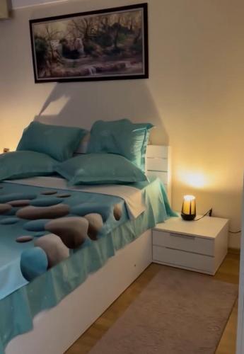 a bedroom with a bed with a blue comforter at Sunshine villa Dzhigurovo in Sandanski