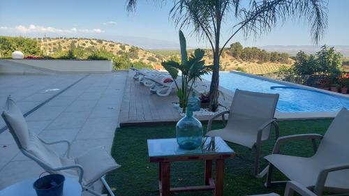a vase sitting on a table next to a pool at Casa del olivo Lucio en Alomartes in Alomartes