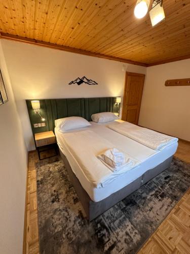 a bedroom with a large bed with a wooden ceiling at Appartements Spitzegel in Hermagor