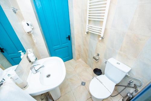a bathroom with a white toilet and a blue door at City Inn - Boutique Hotel Tbilisi in Tbilisi City