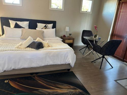 a bedroom with a large bed with two chairs and a table at Joy's Place - Fourways BnB in Sandton